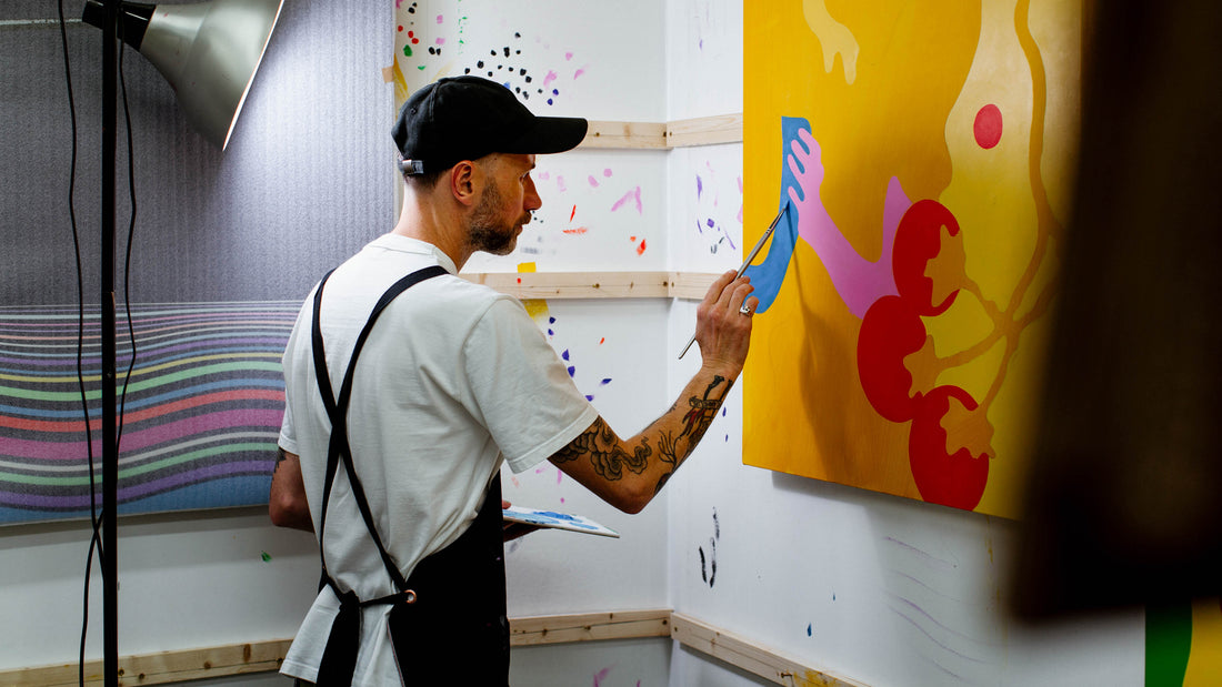 Portrait of UK artist Eelus in his Brighton studio working on a painting